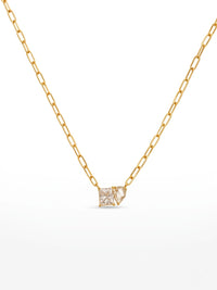 A gold chain necklace with a small square pendant set with clear gemstones, displayed against a plain white background.